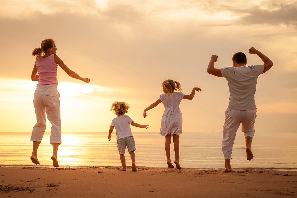 Young family running  watching beach sunset
